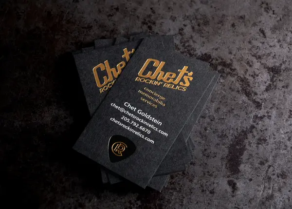 Triple foil stamped business cards with white, gold, and black foil on black paper